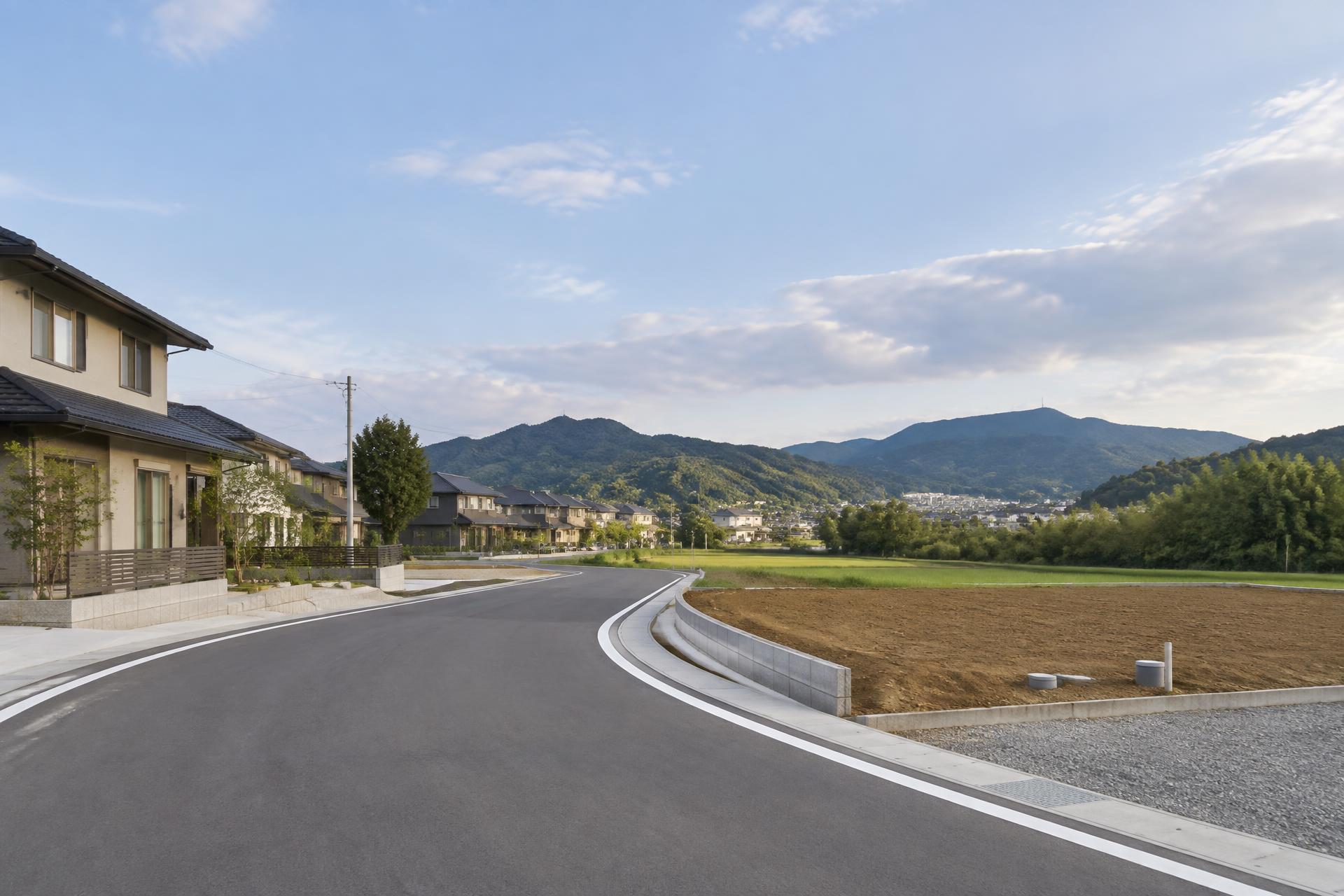 茨城県鉾田市周辺の、整備された道路と住宅、緑地が広がる地域の風景